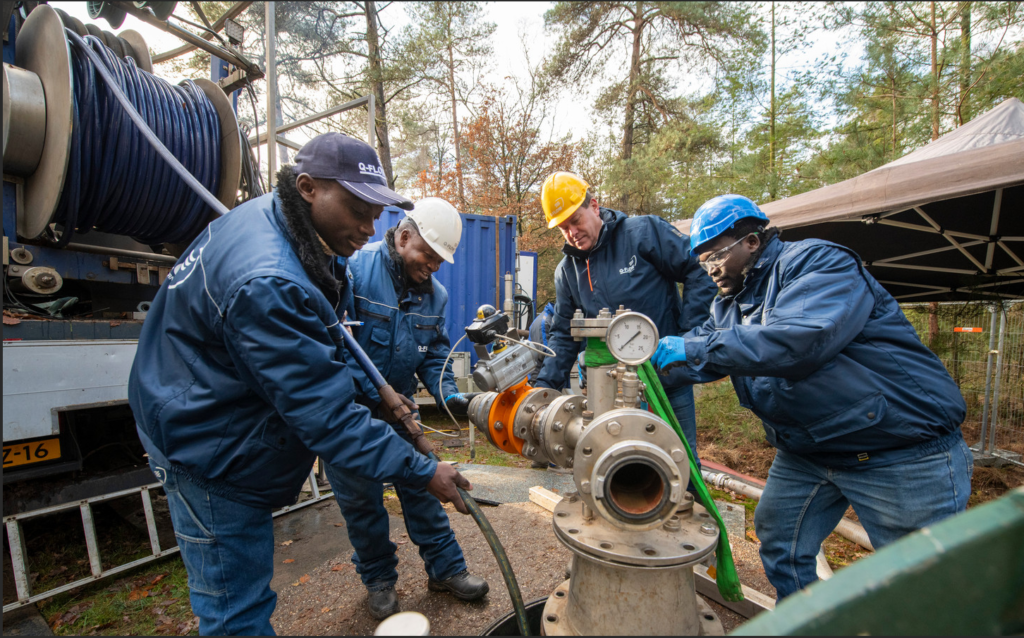 Martin Bloemscheer van het Nijverdalse bedrijf Q-Flow leidt mensen van een Oegandees waterbedrijf op in het regeneren van bronnen. Zij gaan terug naar Oeganda met een installatie van Q-FLow. Links: voorman Hillary Dammie Atuhairwe. © Maarten Sprangh