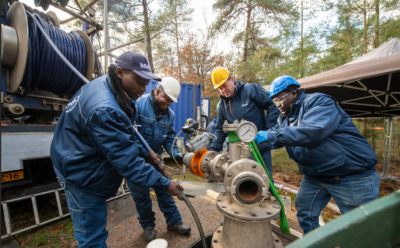 Martin Bloemscheer van het Nijverdalse bedrijf Q-Flow leidt mensen van een Oegandees waterbedrijf op in het regeneren van bronnen. Zij gaan terug naar Oeganda met een installatie van Q-FLow. Links: voorman Hillary Dammie Atuhairwe. © Maarten Sprangh